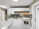 Modern kitchen with white cabinets and a tile backsplash at 1009 Cobblestone Dr, Spring Hill, FL 34606