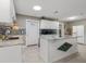 Modern kitchen with white cabinets, granite island, and tile backsplash at 1009 Cobblestone Dr, Spring Hill, FL 34606