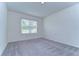 Spacious bedroom with gray carpet and large window with blinds at 15629 Black Pepper Ln, Odessa, FL 33556