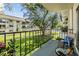 Balcony with seating and view of the lush green courtyard and pool at 4611 W Fig St # 209, Tampa, FL 33609