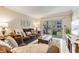 Living room with brown sofas, coffee table, and access to balcony at 4611 W Fig St # 209, Tampa, FL 33609
