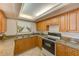 Well-equipped kitchen with wood cabinets, granite countertops and a gas cooktop at 220 Belleview Blvd # 802, Belleair, FL 33756