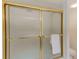 Shower with sliding glass doors and gold accents at 220 Belleview Blvd # 802, Belleair, FL 33756