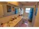 A bathroom with a double sink vanity, and bath tub featuring colorful wallpaper and a blue shower curtain at 7906 Willow Brook Ct, Hudson, FL 34667