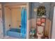 Bathroom featuring vintage tile with a shower-tub combo, storage, and a unique blue color scheme at 7906 Willow Brook Ct, Hudson, FL 34667