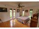 Bright bedroom featuring hardwood floors, ceiling fan, and a large window provides a welcoming and airy space at 7906 Willow Brook Ct, Hudson, FL 34667
