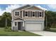 Two-story home with attached garage, landscaping, and large windows at 5700 Spivey Ct, Wesley Chapel, FL 33545