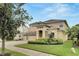 Tan two-story house with three car garage, lush landscaping, and a stone accent at 20123 Oakflower Ave, Tampa, FL 33647