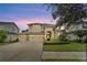 Two-story house exterior with a three-car garage and landscaping at 20123 Oakflower Ave, Tampa, FL 33647