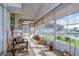 Relaxing screened porch overlooking a tranquil canal; wicker furniture and potted plants at 4976 Britni Way, Zephyrhills, FL 33541