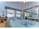 Cozy bedroom with a queen-size bed and mirrored closet doors at 4976 Britni Way, Zephyrhills, FL 33541