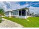 Single-story home with screened porch, and grassy backyard at 4976 Britni Way, Zephyrhills, FL 33541
