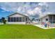 Landscaped backyard with patio furniture and lush green grass at 4976 Britni Way, Zephyrhills, FL 33541