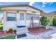 Front view of charming single-wide mobile home with porch swing at 35210 Condominium Blvd, Zephyrhills, FL 33541