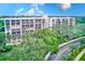 Multi-story condo building with lush landscaping and a road at 220 Belleview Blvd # 802, Belleair, FL 33756