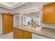 Kitchen with wood cabinets, granite counters, and views to living room at 220 Belleview Blvd # 802, Belleair, FL 33756