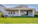 A covered back patio, ideal for outdoor entertaining, overlooks a lush green lawn and landscaping at 1946 Longliner Loop, Wesley Chapel, FL 33543