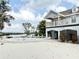 Backyard view of two story home with balcony, pool, waterfront, and sandy yard at 6710 Myrna Dr, Tampa, FL 33619