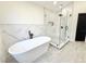 Bathroom showcases freestanding tub and glass-enclosed shower with marble-style tile at 6710 Myrna Dr, Tampa, FL 33619