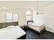 Bright bedroom featuring two twin beds, modern ceiling fan, and light-filled windows at 6710 Myrna Dr, Tampa, FL 33619
