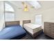 Bright bedroom featuring two beds, a ceiling fan, skylight, and a light-colored dresser at 6710 Myrna Dr, Tampa, FL 33619