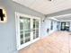 Patio with view of the house, outdoor lighting, french doors, and light colored tile at 6710 Myrna Dr, Tampa, FL 33619