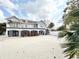 View of two-story home with balcony, covered patio, and sandy yard at 6710 Myrna Dr, Tampa, FL 33619