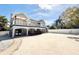 Exterior of home featuring balcony, covered patio, and spacious sandy yard at 6710 Myrna Dr, Tampa, FL 33619