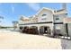 Exterior view of home featuring an upper balcony, lower patio, and sandy yard at 6710 Myrna Dr, Tampa, FL 33619