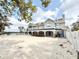 Two story home with balcony and view of backyard with sandy space at 6710 Myrna Dr, Tampa, FL 33619