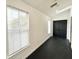 Bright hallway with white walls, black floors, and natural light filtering through a large window at 6710 Myrna Dr, Tampa, FL 33619