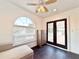 Living room with hardwood floors, a ceiling fan, arched window, and door to balcony at 6710 Myrna Dr, Tampa, FL 33619
