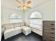 Comfortable living room with a gray couch, arched windows, and a ceiling fan at 6710 Myrna Dr, Tampa, FL 33619