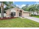 Tan house with a two-car garage and manicured lawn at 35230 Meadow Reach Dr, Zephyrhills, FL 33541