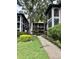 Condo building featuring well-manicured lawns, lush landscaping, and a charming walkway leading to the units at 3399 Mermoor Dr # 207, Palm Harbor, FL 34685