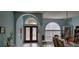 Bright entryway with double doors, arched windows, column, and tile flooring at 4467 Worthington Ct, Palm Harbor, FL 34685