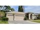 Welcoming home featuring a three-car garage and well-maintained landscaping, enhancing its curb appeal at 4467 Worthington Ct, Palm Harbor, FL 34685
