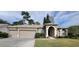 Charming single-story home featuring a three-car garage, manicured lawn, and inviting front entrance at 4467 Worthington Ct, Palm Harbor, FL 34685