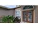 Inviting front entrance featuring double doors with decorative glass, sidelights, and lush landscaping at 4467 Worthington Ct, Palm Harbor, FL 34685