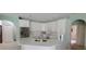 Stylish kitchen featuring white cabinets, stainless steel appliances, and a large island at 4467 Worthington Ct, Palm Harbor, FL 34685