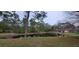 Expansive backyard view featuring a serene pond surrounded by lush trees and greenery at 4467 Worthington Ct, Palm Harbor, FL 34685