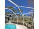 Screened-in pool with a view of the pond and mature trees at 4467 Worthington Ct, Palm Harbor, FL 34685
