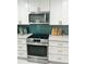 Modern kitchen with stainless steel appliances, a stylish backsplash, and white cabinets at 4810 Chancellor Ne St, St Petersburg, FL 33703