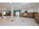Expansive room with tile floors, frameless walls, and open access to the kitchen needing drywall and renovation at 4810 Chancellor Ne St, St Petersburg, FL 33703