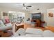 Living room with sectional sofa, TV, and wood floors at 3399 Mermoor Dr # 207, Palm Harbor, FL 34685