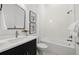 Modern bathroom with white subway tile, soaking tub, and dark vanity at 6166 Winding Pine Dr, Nokomis, FL 34275