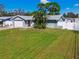 Single story home with light gray exterior, attached garage, and grassy yard at 11303 86Th Ave, Seminole, FL 33772