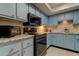Light blue kitchen cabinets, granite countertops, and modern appliances at 9537 86Th Ave # 9537, Seminole, FL 33777