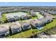 An aerial showcases the backyard of homes, some with pools, overlooking green spaces and a lake at 32707 Tamarind Grove Ln, Wesley Chapel, FL 33543