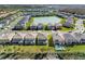 Aerial view of neighborhood featuring houses, a central lake, and manicured lawns at 32707 Tamarind Grove Ln, Wesley Chapel, FL 33543